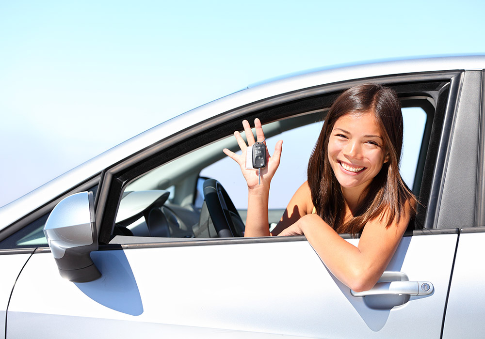 Asian,Car,Driver,Woman,Smiling,Showing,New,Car,Keys,And Donna al volante